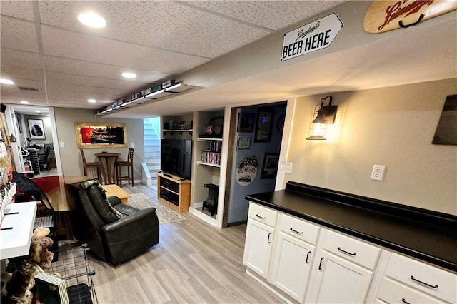 living room featuring light hardwood / wood-style floors and a paneled ceiling