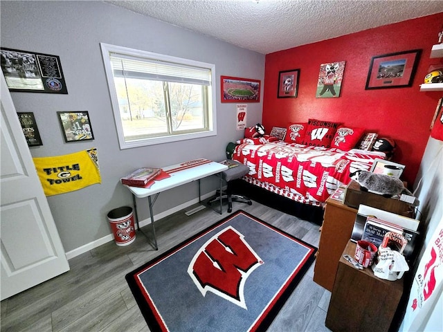 bedroom with a textured ceiling and wood-type flooring