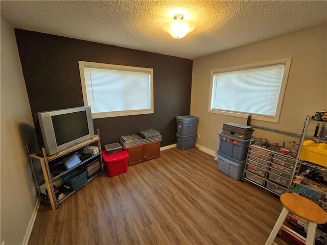 misc room with a textured ceiling and hardwood / wood-style floors