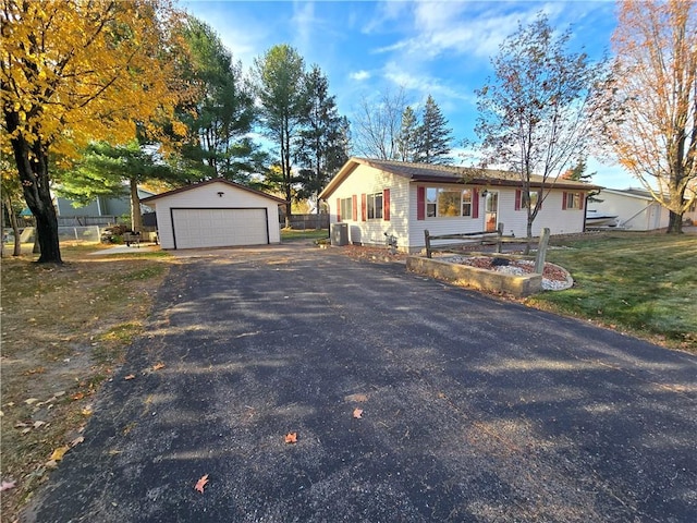 ranch-style home with cooling unit, an outdoor structure, a garage, and a front lawn