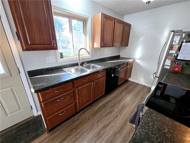 kitchen with dishwasher, dark wood-type flooring, sink, a textured ceiling, and stainless steel refrigerator