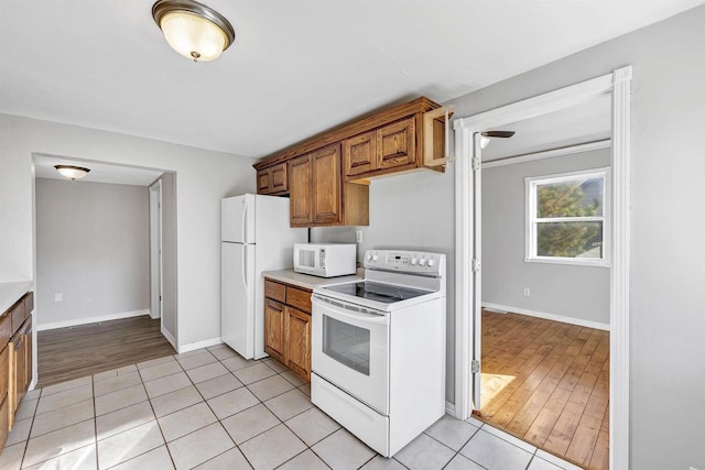 kitchen with white appliances and light hardwood / wood-style flooring