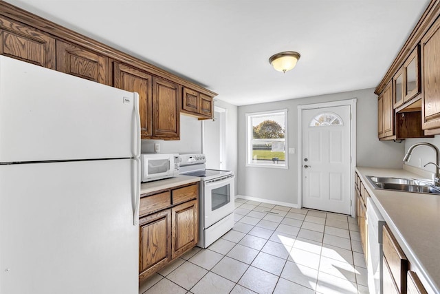 kitchen with sink, light tile patterned flooring, and white appliances