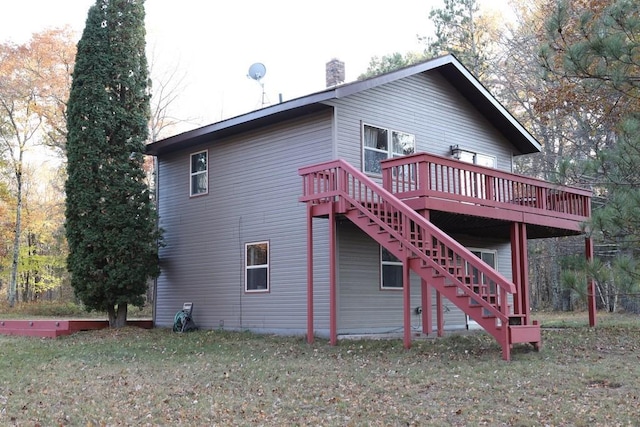 rear view of house featuring a deck and a yard