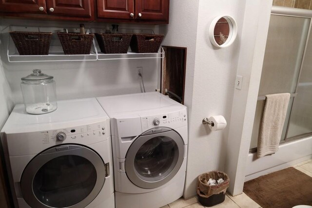 laundry area with washer and clothes dryer and light tile patterned floors