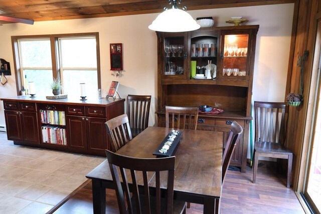 dining space with light hardwood / wood-style flooring and wood ceiling