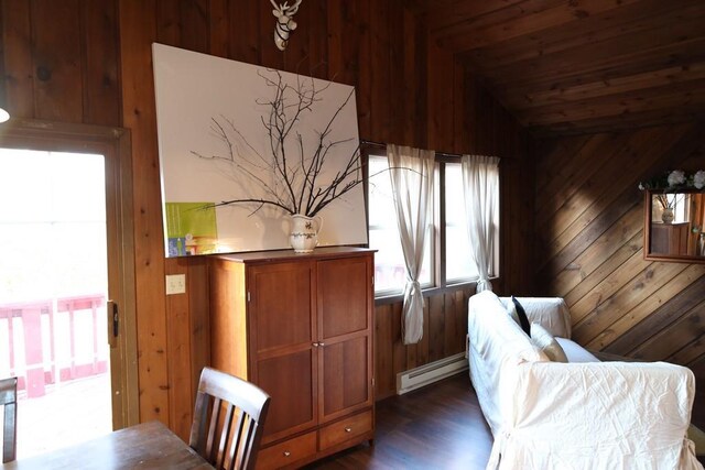 sitting room featuring wood walls, lofted ceiling, baseboard heating, and dark hardwood / wood-style floors