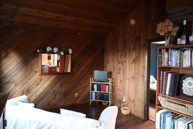 bedroom with hardwood / wood-style flooring, wood walls, wooden ceiling, and vaulted ceiling