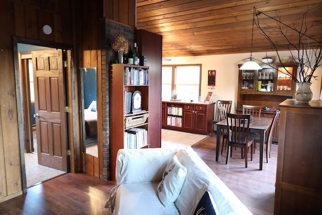 interior space with light hardwood / wood-style flooring, wood walls, and wooden ceiling