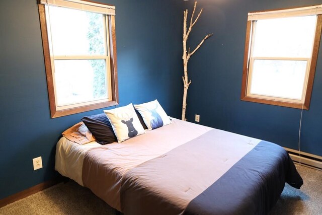 bedroom featuring baseboard heating and carpet