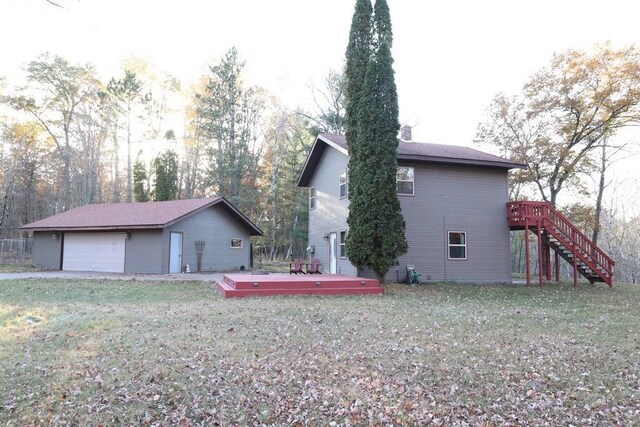 back of house featuring a deck and a lawn