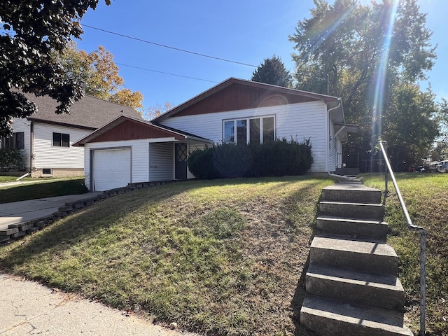 single story home featuring a garage, a front lawn, and an outbuilding