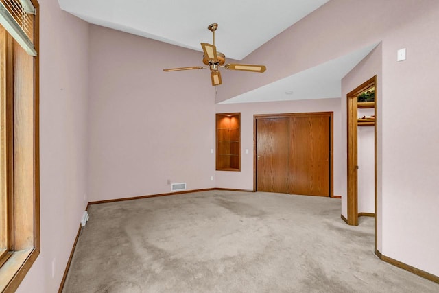 unfurnished bedroom with light carpet, vaulted ceiling, and ceiling fan