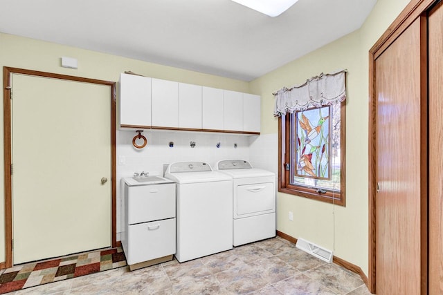 clothes washing area with cabinets, independent washer and dryer, and sink