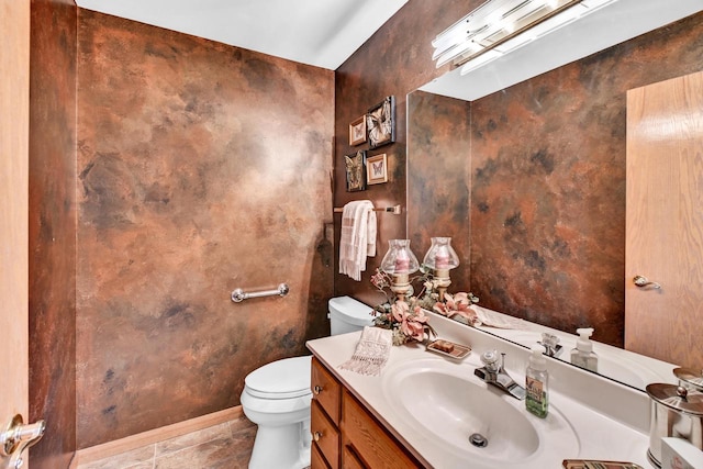 bathroom with toilet, vanity, and tile patterned flooring