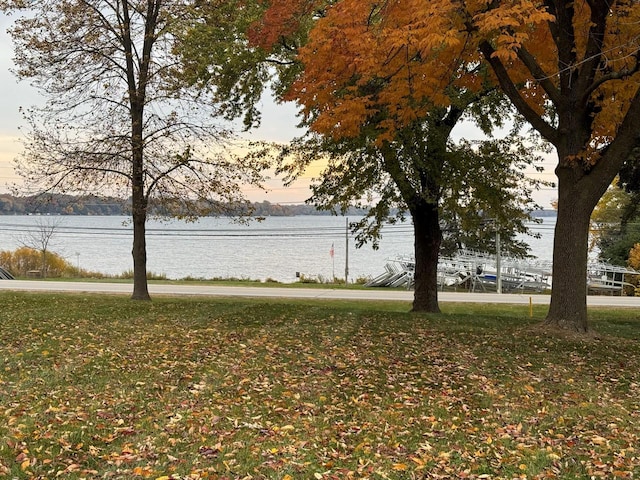 yard at dusk featuring a water view