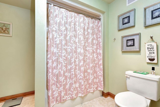 bathroom featuring toilet, shower / bath combo, and tile patterned flooring