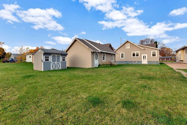 rear view of house with a storage unit and a yard