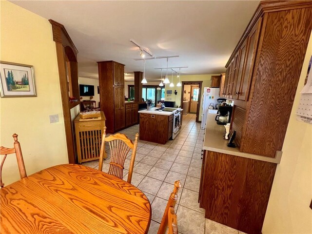 dining space featuring light tile patterned flooring and track lighting