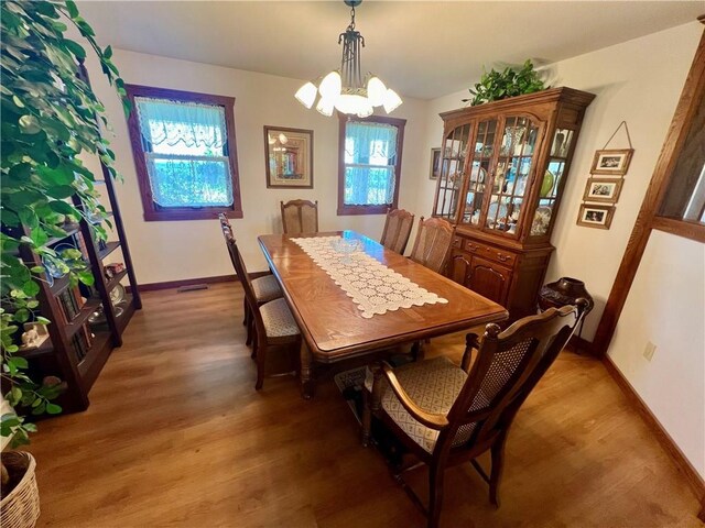 dining space with a notable chandelier and wood-type flooring