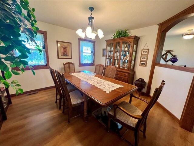 dining space featuring a notable chandelier and wood-type flooring