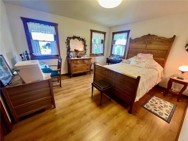 bedroom with multiple windows and light wood-type flooring