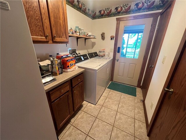 washroom with washer and dryer, cabinets, and light tile patterned flooring