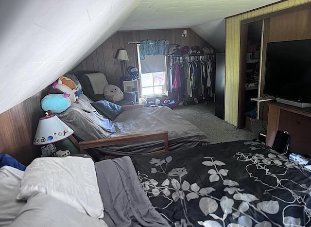 carpeted bedroom featuring wood walls and vaulted ceiling