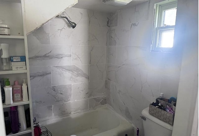 bathroom with toilet and tiled shower / bath combo