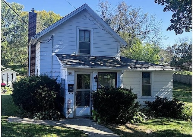 view of front of house featuring a shed and a front lawn