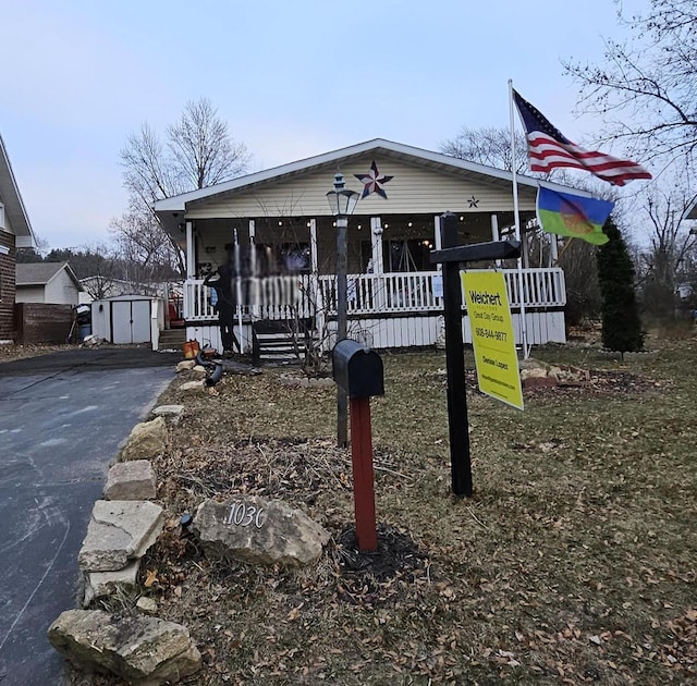 manufactured / mobile home with covered porch and a storage shed