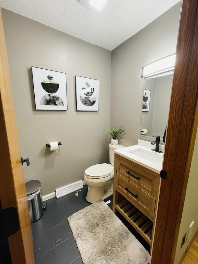 bathroom with vanity, toilet, and tile patterned floors