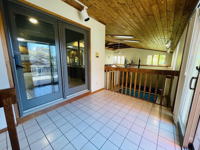 interior space featuring vaulted ceiling with skylight and wooden ceiling