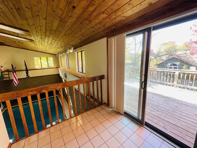 doorway to outside featuring wood ceiling, vaulted ceiling, plenty of natural light, and tile patterned flooring