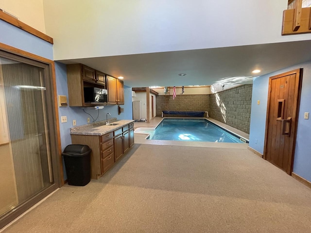 view of swimming pool featuring sink and a jacuzzi