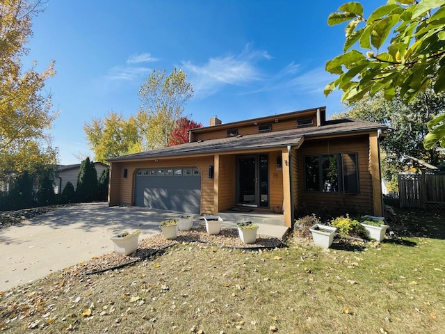 view of front of property with a porch, a front lawn, and a garage