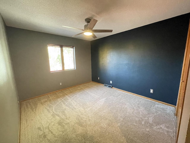 carpeted empty room featuring a textured ceiling and ceiling fan