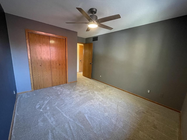 unfurnished bedroom featuring a closet, carpet, and ceiling fan