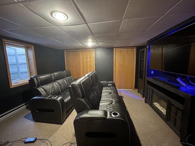 carpeted cinema with a paneled ceiling