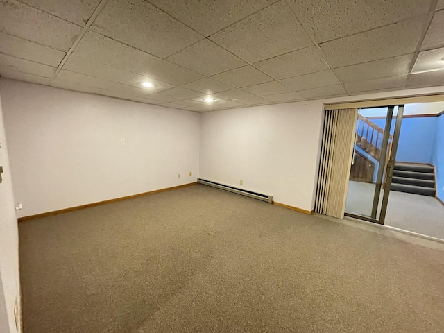 spare room with baseboard heating, carpet floors, and a paneled ceiling