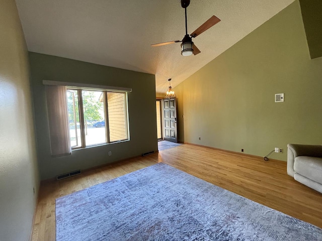 unfurnished living room featuring ceiling fan, vaulted ceiling, and light wood-type flooring