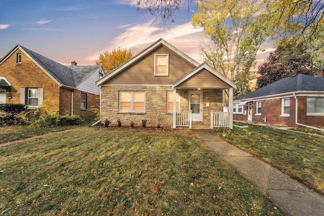 view of front of home with covered porch and a lawn