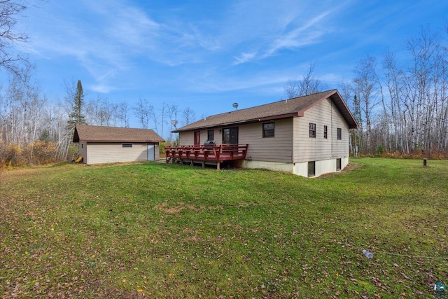 rear view of house featuring an outdoor structure, a wooden deck, and a lawn