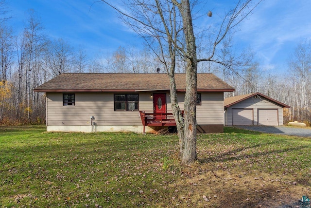 ranch-style house featuring a front yard, a garage, a deck, and an outbuilding