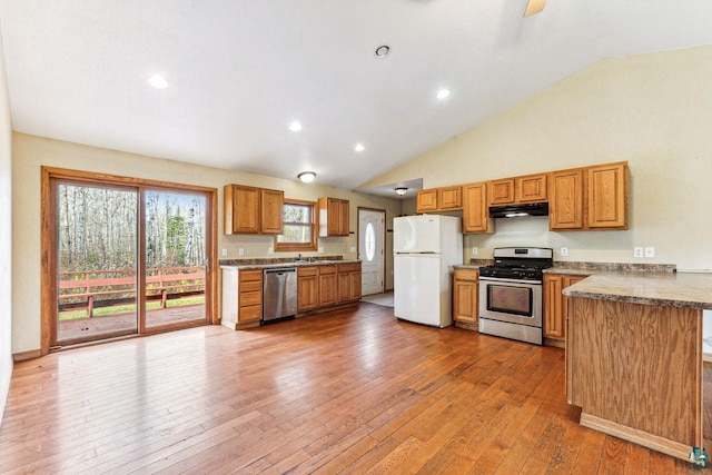 kitchen with high vaulted ceiling, stainless steel appliances, wood-type flooring, and sink