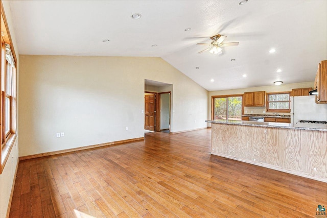 kitchen featuring dishwasher, light wood-type flooring, kitchen peninsula, vaulted ceiling, and white fridge