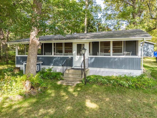 view of front of house with a sunroom and a front yard