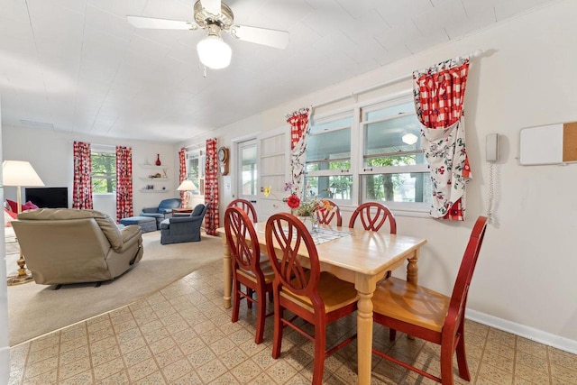 carpeted dining area with ceiling fan