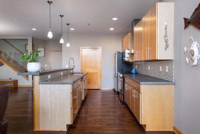 kitchen featuring sink, stainless steel electric range, pendant lighting, dark hardwood / wood-style floors, and a kitchen island with sink