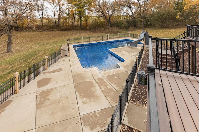 view of pool featuring a water slide, a patio, and a lawn